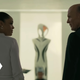 Charlotte Hale and William stare with sinister glee at each other with a strange device in front of them.